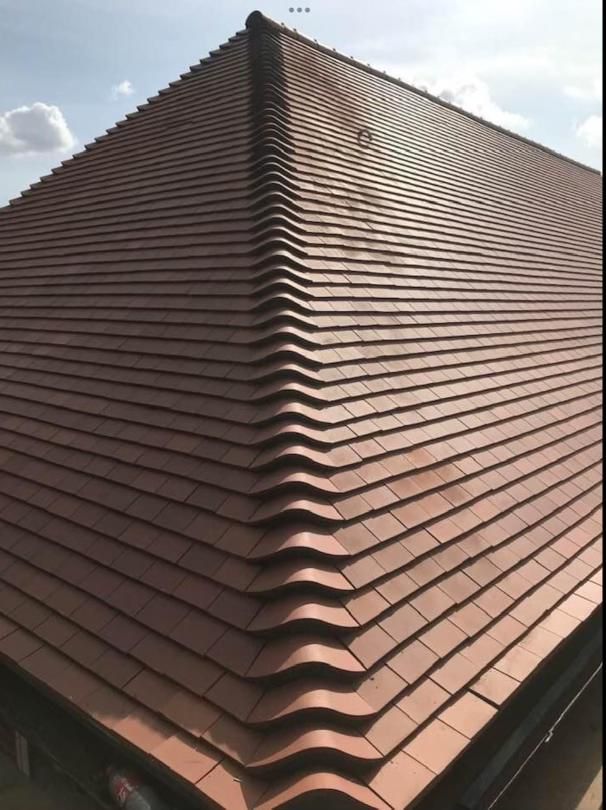 Newly tiled hipped roof completed by AimHigher Roofing in Whitton